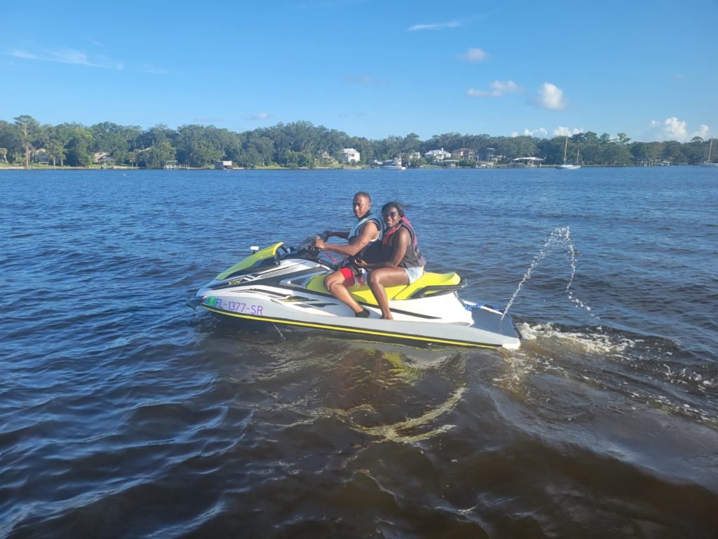 couple riding a jet ski near down town jacksonville fl