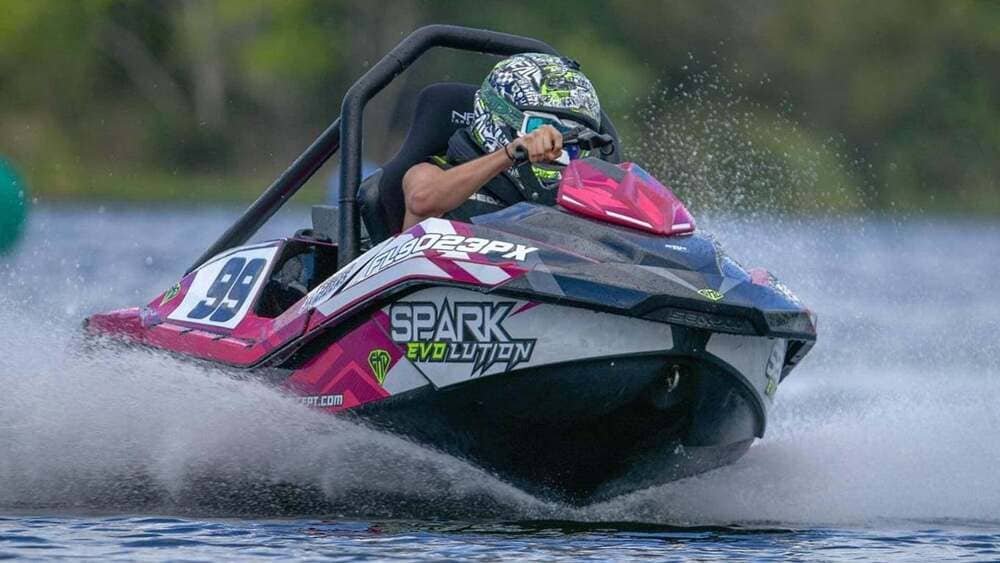 A helmeted rider driving an EvoJet Spark Evolution jet kart