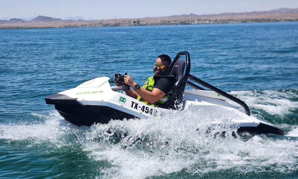 An EvoJet mini jet boat throwing spray on the water